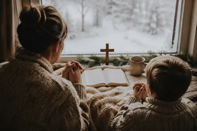 Mother and Child Praying by Winter Window