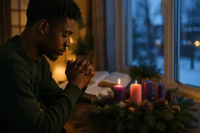 Man Praying Beside Advent Wreath Candle