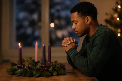 Young Man Praying Beside Advent Wreath