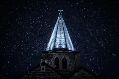 Snow Falling on Church Steeple at Night