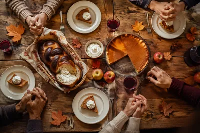Thanksgiving Family Prayer Around Rustic Dinner Table