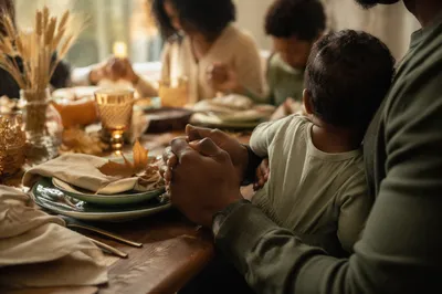 Thanksgiving Family Prayer Around Cozy Dinner Table