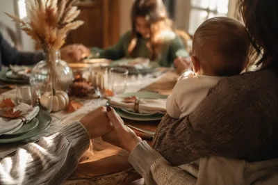 Thanksgiving Family Prayer Around Wooden Table