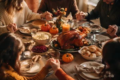 Thanksgiving Family Prayer Around Rustic Dinner Table