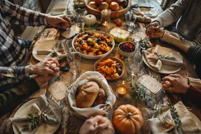 Thanksgiving Family Prayer Around Rustic Dinner Table
