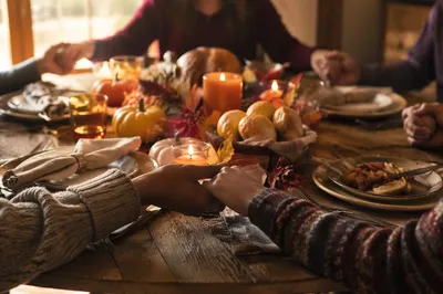 Thanksgiving Family Prayer Around Rustic Dinner Table