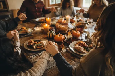 Thanksgiving Family Prayer Around Rustic Dinner Table
