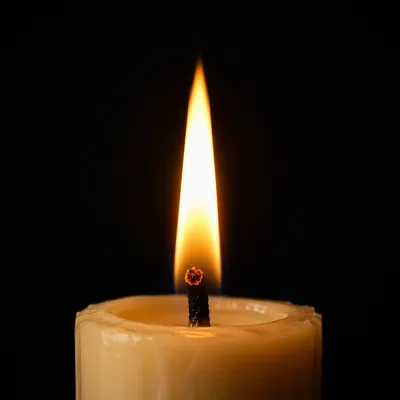 Single Candle Flame on Dark Background