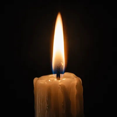 Single Candle Flame on Dark Background