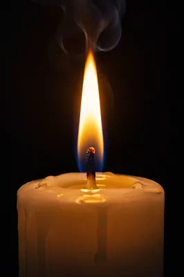 Single Candle Flame on Dark Background