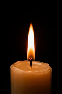 Single Candle Flame on Dark Background