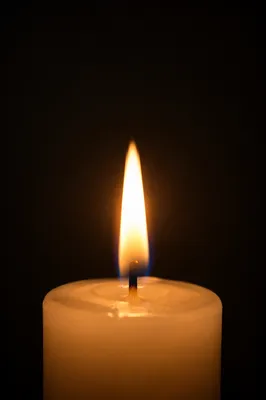Single Candle Flame on Dark Background