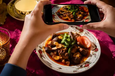 Hands Photographing Spicy Dish for Social Sharing