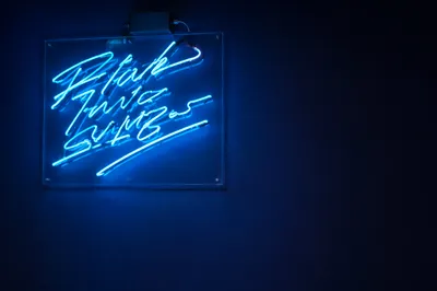 Cyan Neon Motivation Sign on Dark Wall