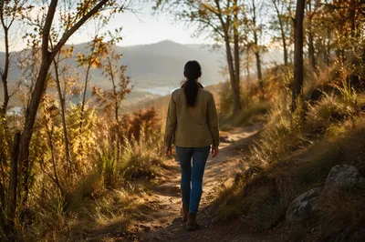 Woman Walking Along Autumn Nature Path