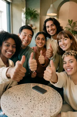 Diverse Friends Giving Thumbs Up Indoors