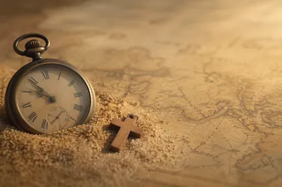 Pocket Watch on Sand and Vintage Map