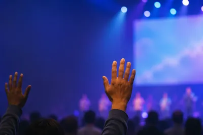 Raised Hands in Blurred Church Auditorium
