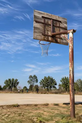 Weathered Rural Basketball Hoop Under Blue Sky