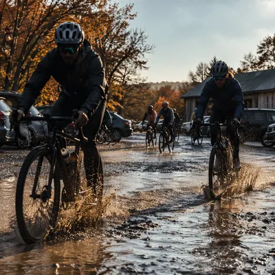 Cyclists Splashing Through Autumn Trailhead Puddle