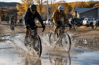 Cyclists Splashing Through Autumn Trail Puddle