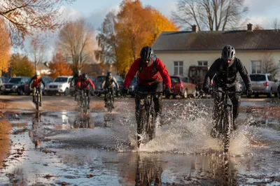 Cyclists Splash Through Autumn Mountain Puddle