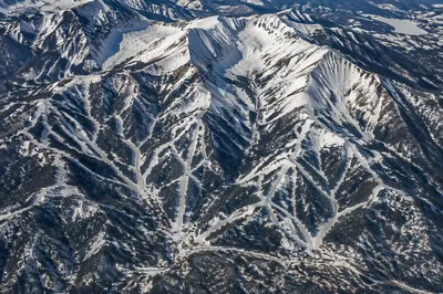 Aerial Winter Ski Runs Over Rugged Mountains