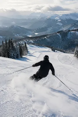Lone Skier Descending Snowy Alpine Slope