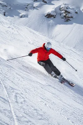 Skier Carving Down Steep Snowy Slope