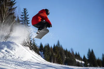 Red Jacket Snowboarder Jumping Downhill Mountain