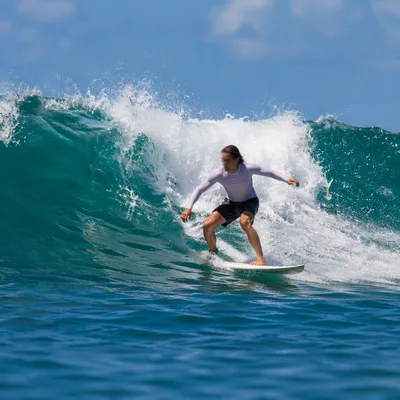 Surfer Riding Turquoise Ocean Wave