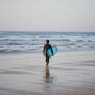 Surfer Walking Toward Gentle Summer Waves