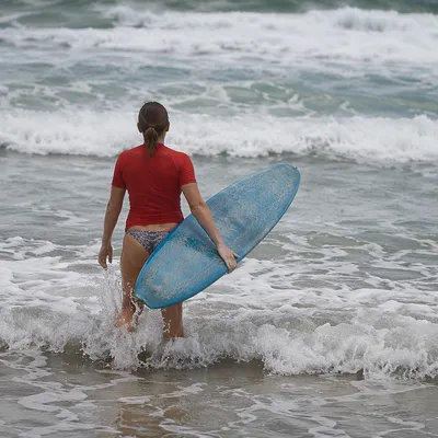 Surfer Entering Foamy Summer Ocean