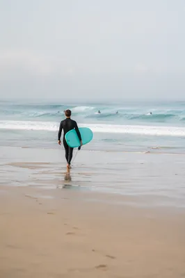 Surfer Walking Toward Gentle Summer Waves
