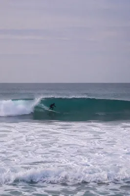 Distant Surfer Riding Teal Summer Wave
