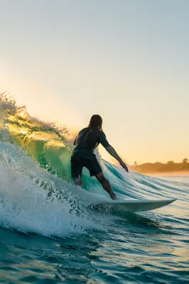 Surfer Riding Turquoise Wave at Golden Hour