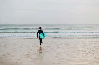 Surfer Walking Toward Gentle Summer Waves