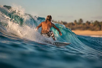 Surfer Riding Turquoise Wave at Golden Hour