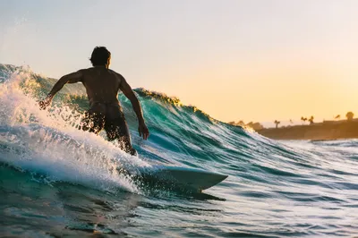 Surfer Riding Turquoise Wave at Golden Hour