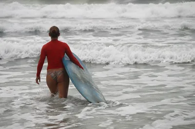 Surfer Entering Summer Waves with Blue Longboard