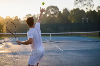 Early Morning Tennis Serve on Outdoor Court