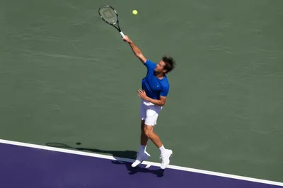 Tennis Player Mid-Serve on Outdoor Court