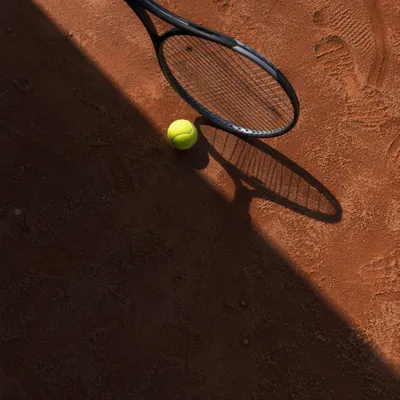 Tennis Racket and Ball on Clay Court