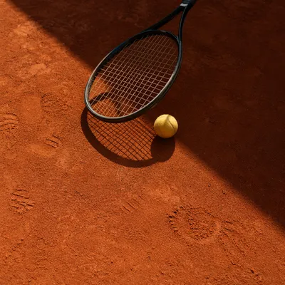Tennis Racket and Ball on Clay Court