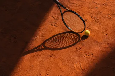 Tennis Racket and Ball on Clay Court