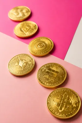 Golden Cryptocurrency Tokens on Pink Tabletop