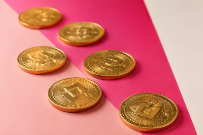 Golden Cryptocurrency Tokens on Pink Tabletop