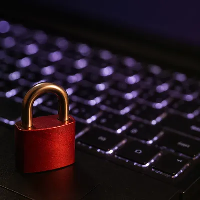 Red Padlock on Glowing Laptop Keyboard