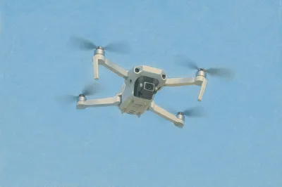 Quadcopter Drone Hovering in Clear Blue Sky