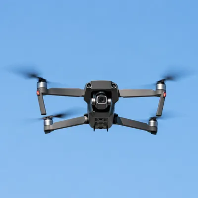 Modern Camera Drone Hovering in Blue Sky